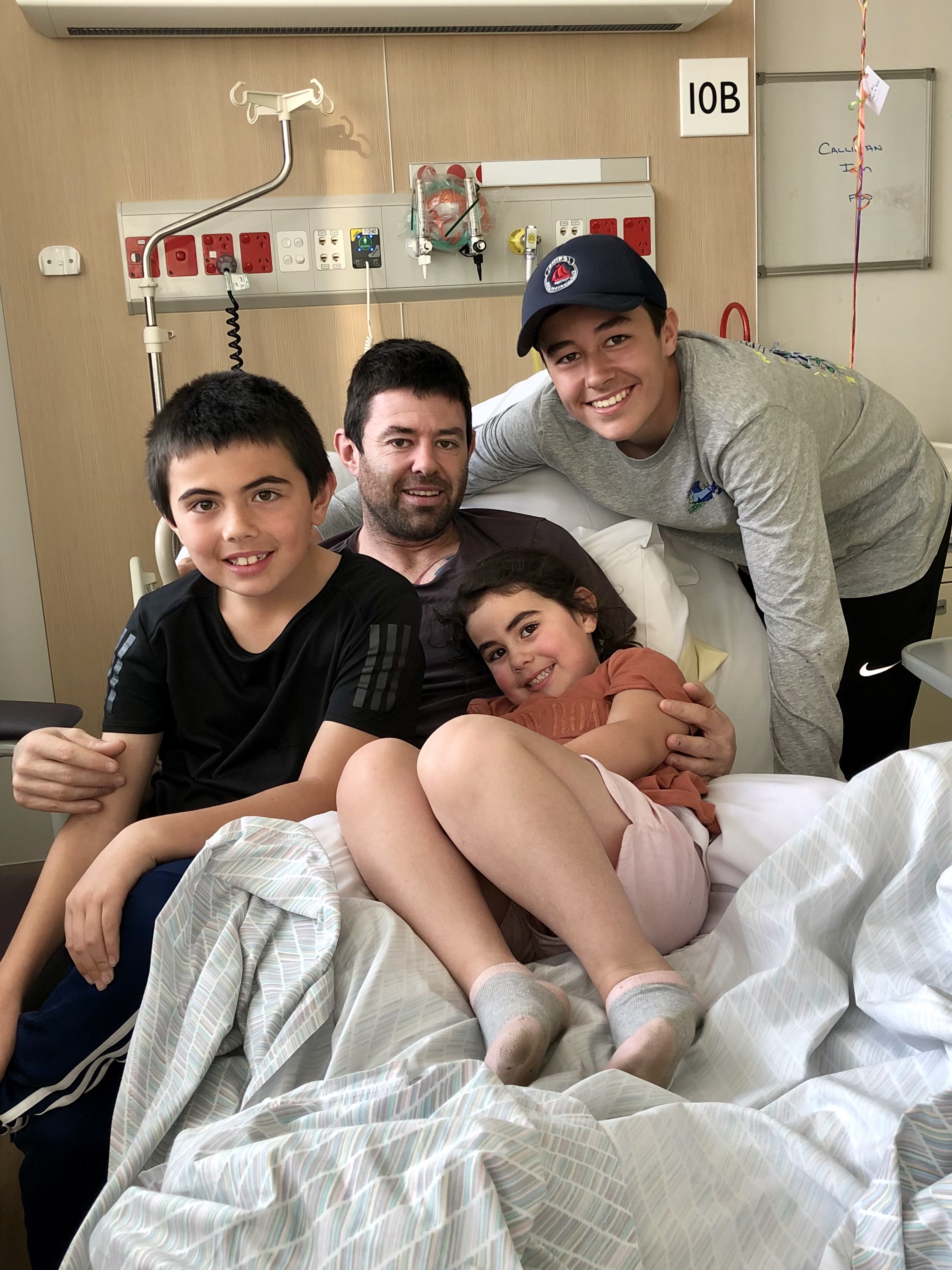 Ian Callinan in hospital with his children visiting him after his stroke